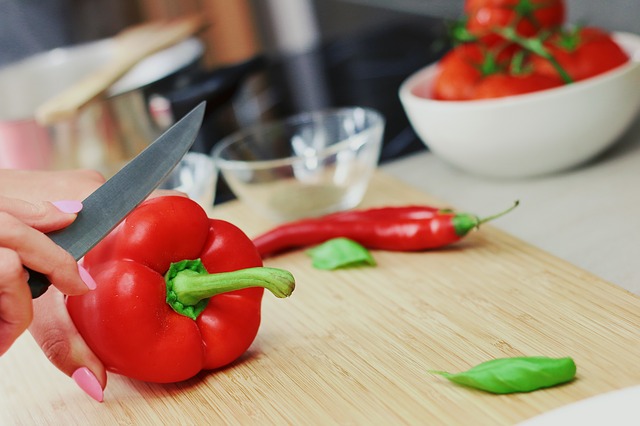 Photo of hands chopping a red bell pepper