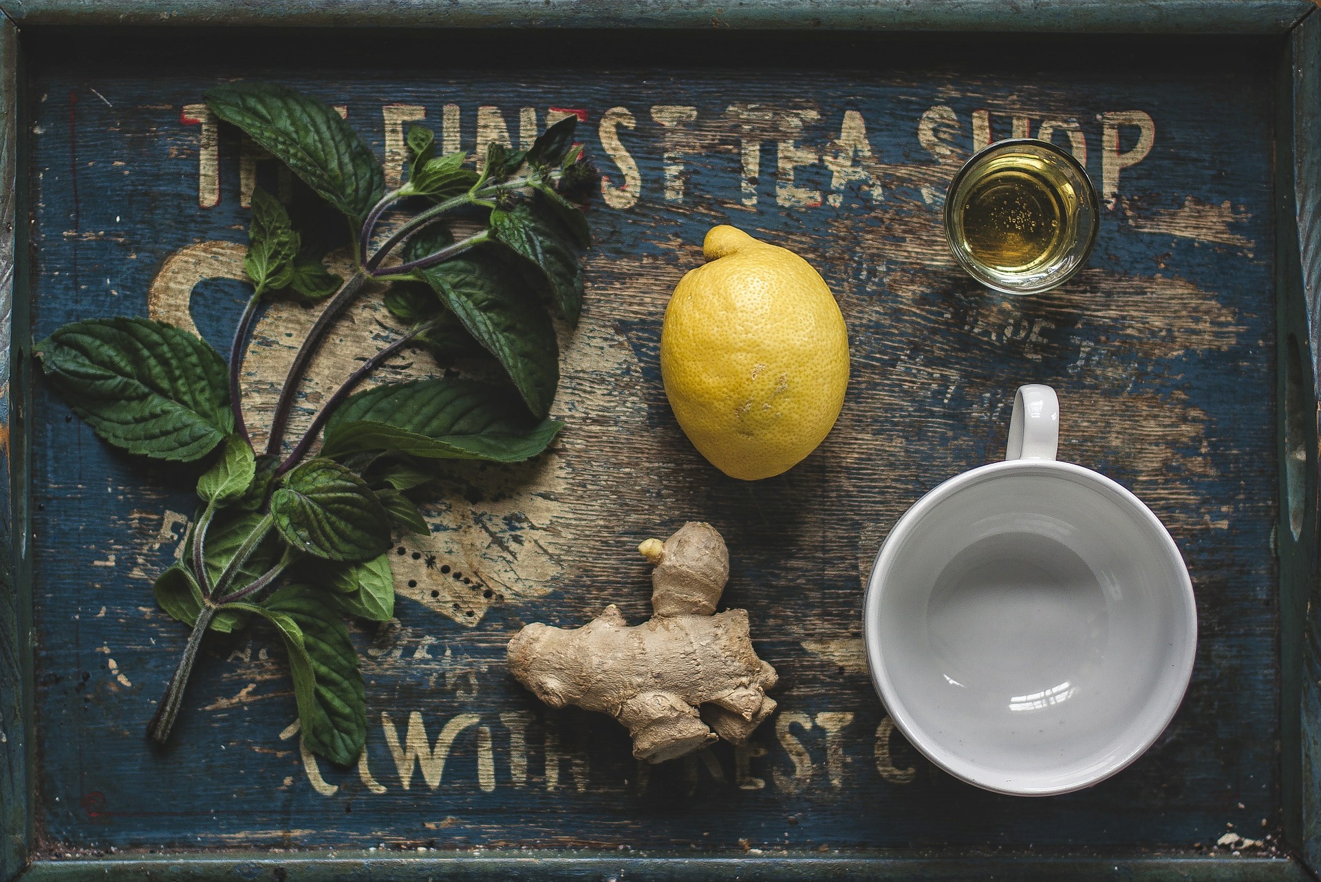 Leaves, gingerroot, and lemon on tea tray with mug